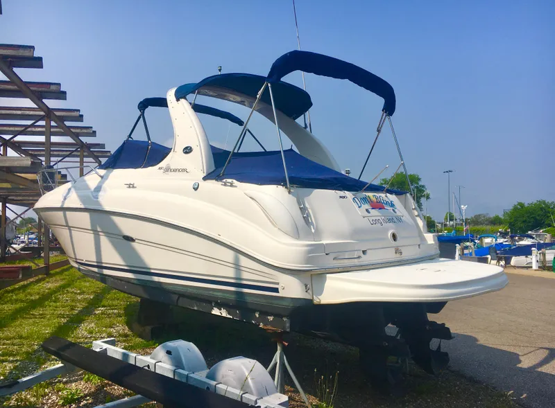 Slide: The Image of 2004 Sea Ray 280 Sundancer boat on trailer, blue canopy, parked outdoors. - 2