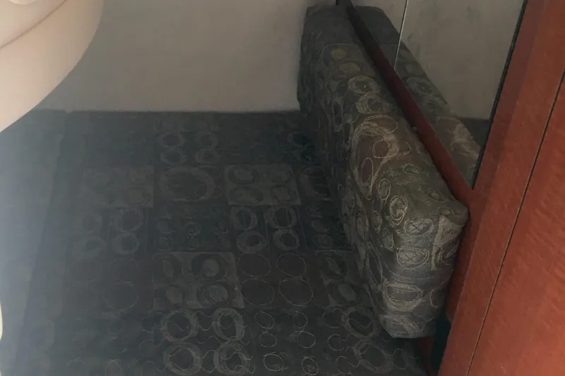 Slide: The Image of 2004 Sea Ray 280 Sundancer cabin interior with patterned upholstery and wooden accents. - 25