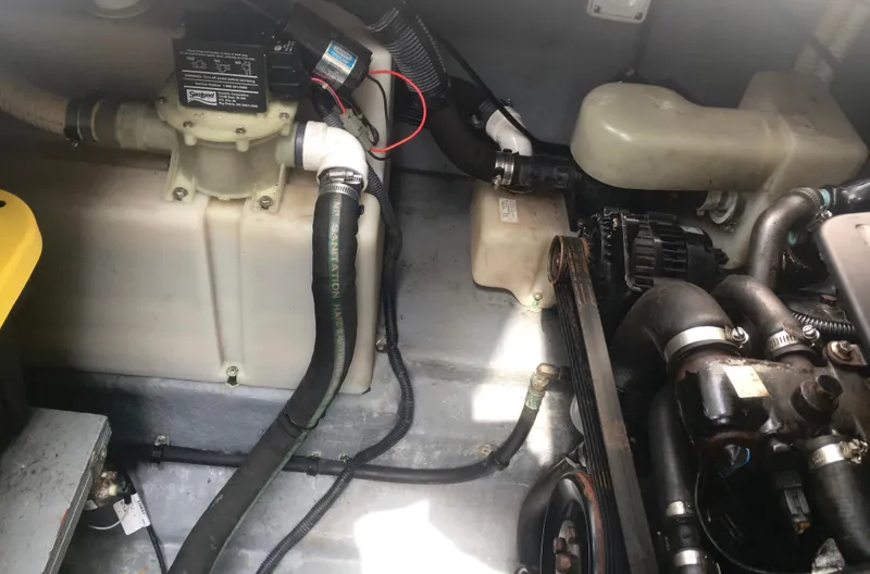 Slide: The Image of Engine compartment of a 2004 Sea Ray 280 Sundancer boat, showing hoses and components. - 27