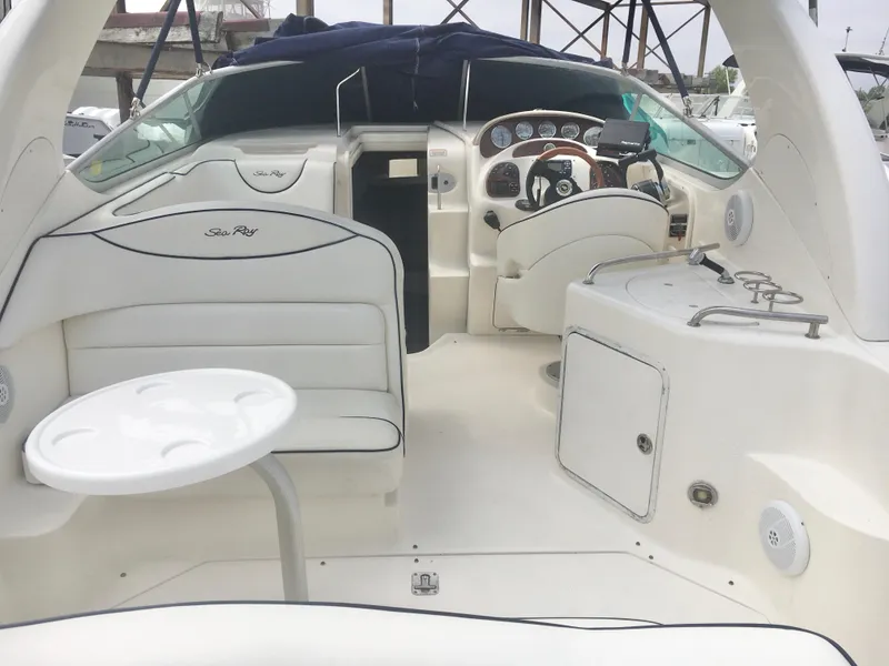 Slide: The Image of 2004 Sea Ray 280 Sundancer boat interior with seating, table, and helm. - 4
