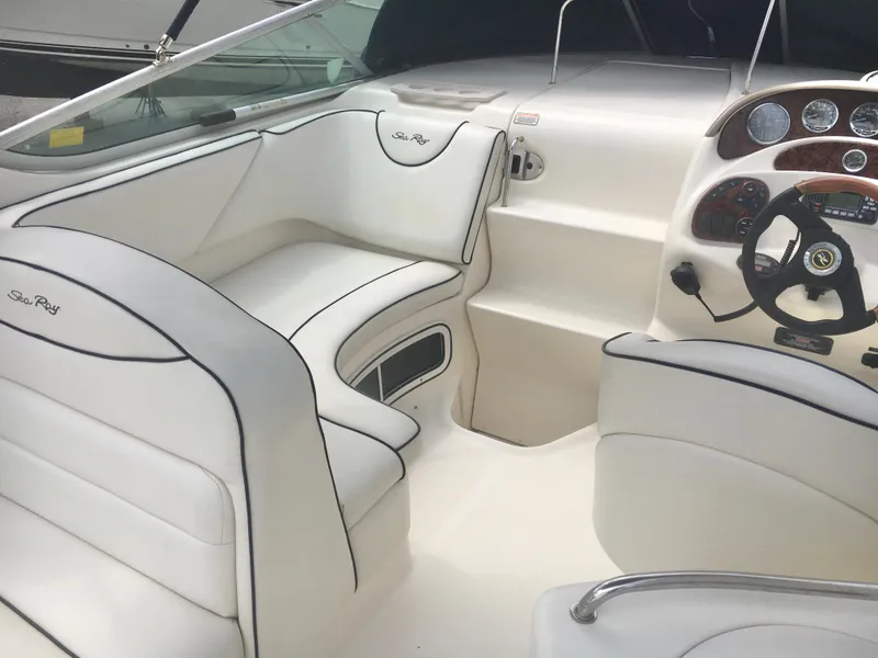 Slide: The Image of 2004 Sea Ray 280 Sundancer boat interior with white seating and control panel. - 5