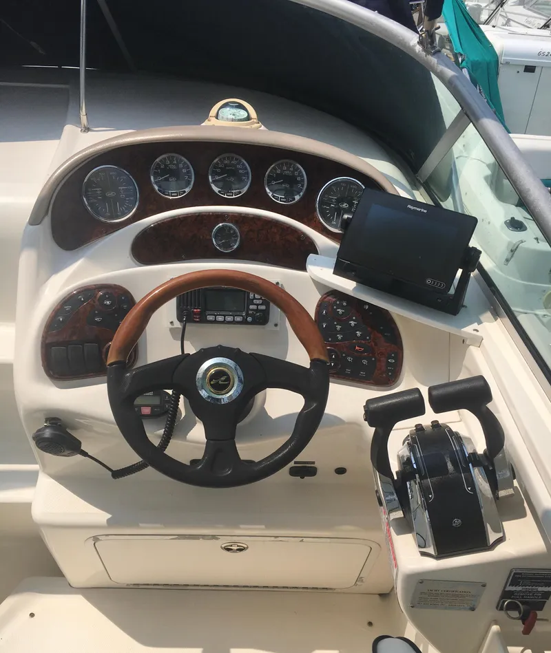 Slide: The Image of 2004 Sea Ray 280 Sundancer helm with gauges, steering wheel, and navigation equipment. - 7