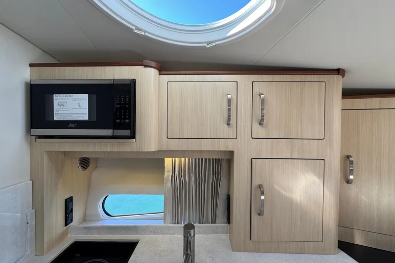 Slide: The Image of Modern kitchen interior of 2026 Regal 33 XO boat with microwave and cabinets. - 103