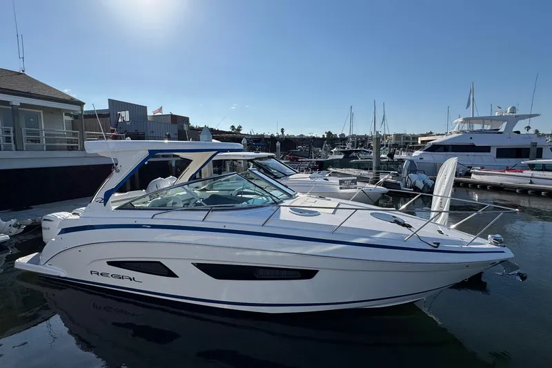 Slide: The Image of 2026 Regal 33 XO boat docked at marina, sleek design, sunny day. - 12