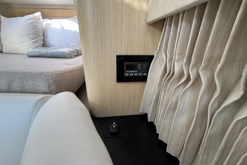 Slide: The Image of 2026 Regal 33 XO cabin interior with control panel, bed, and curtains. - 127