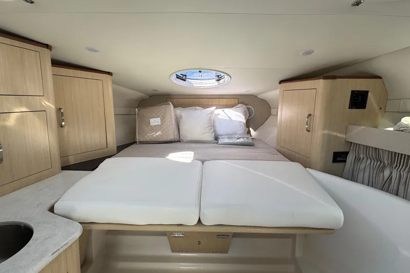 Slide: The Image of Luxurious cabin interior of 2026 Regal 33 XO yacht with cozy bed and wooden cabinetry. - 129