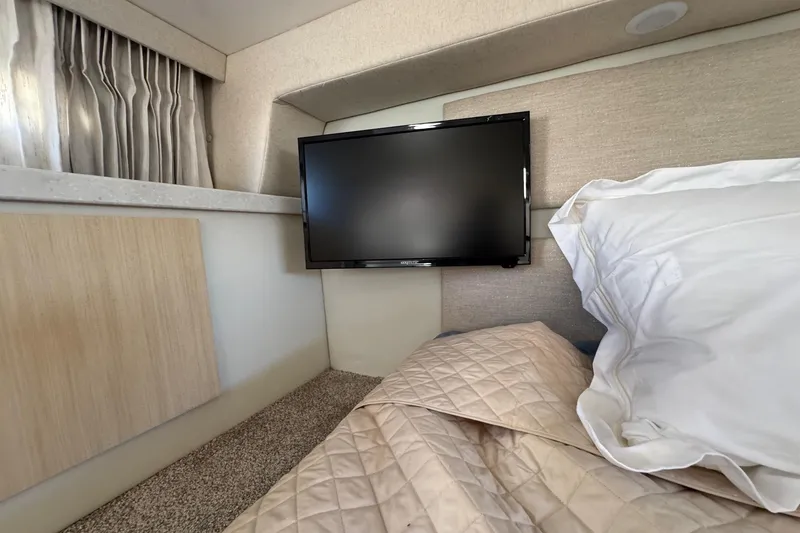 Slide: The Image of Interior of 2026 Regal 33 XO yacht cabin with TV, bed, and curtains. - 140