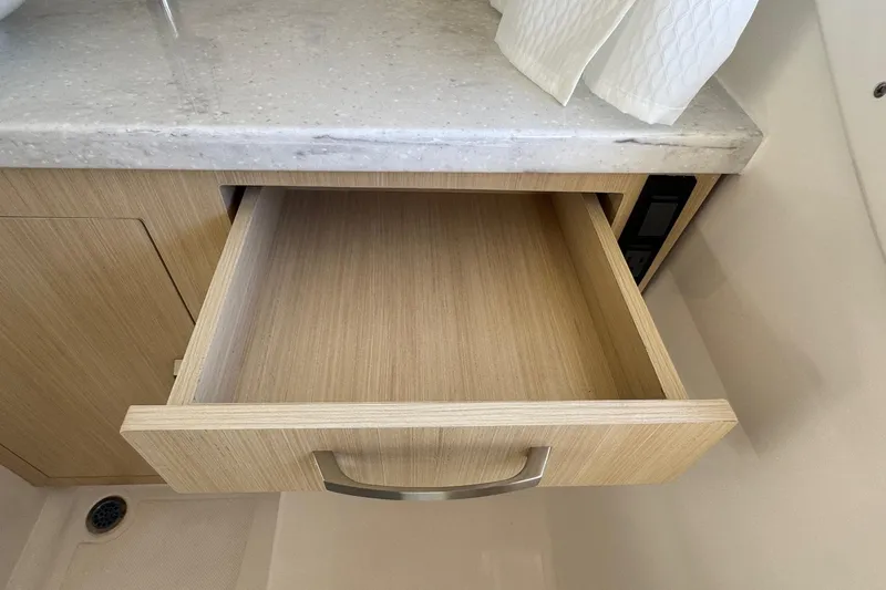 Slide: The Image of Open wooden drawer in 2026 Regal 33 XO boat interior. - 154