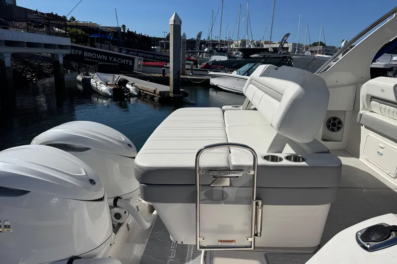 Slide: The Image of 2026 Regal 33 XO boat with white seating and dual outboard engines at a marina. - 39