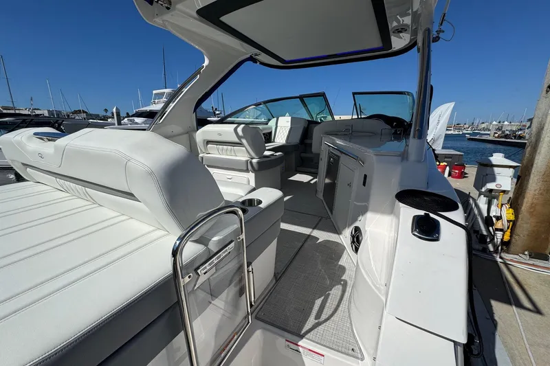 Slide: The Image of 2026 Regal 33 XO luxury boat interior with white seating and modern amenities at a marina. - 44