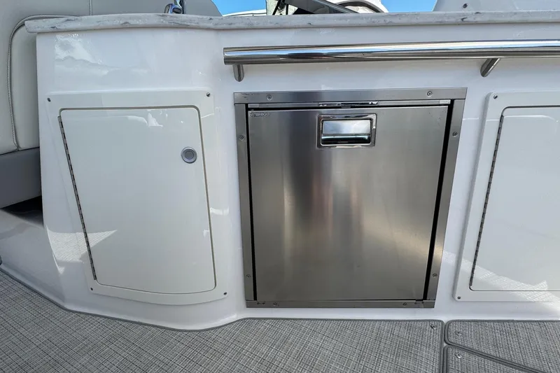 Slide: The Image of 2026 Regal 33 XO boat interior with stainless steel fridge and white cabinetry. - 48