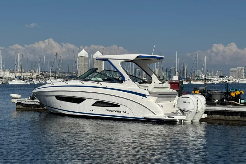 Slide: The Image of 2026 Regal 33 XO boat docked in marina with city skyline background. - 5
