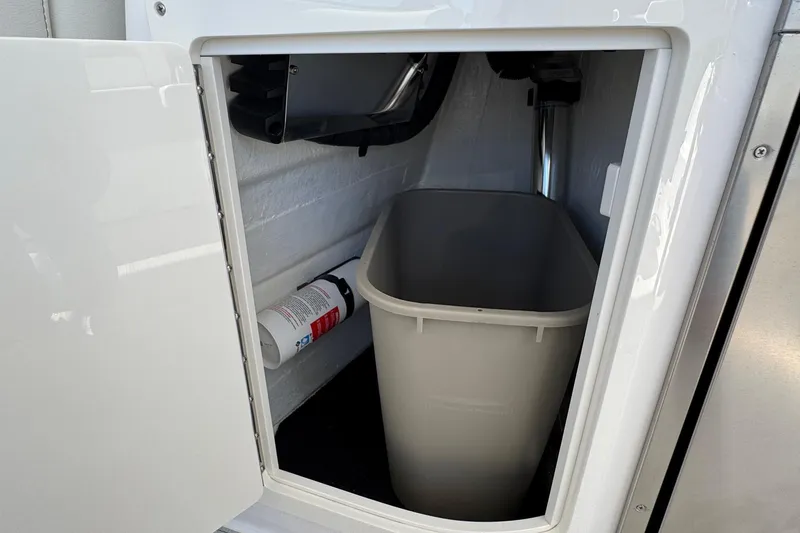 Slide: The Image of Storage compartment with trash bin and fire extinguisher in 2026 Regal 33 XO boat. - 51