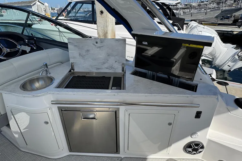 Slide: The Image of 2026 Regal 33 XO yacht kitchenette with sink, grill, and storage at marina. - 53