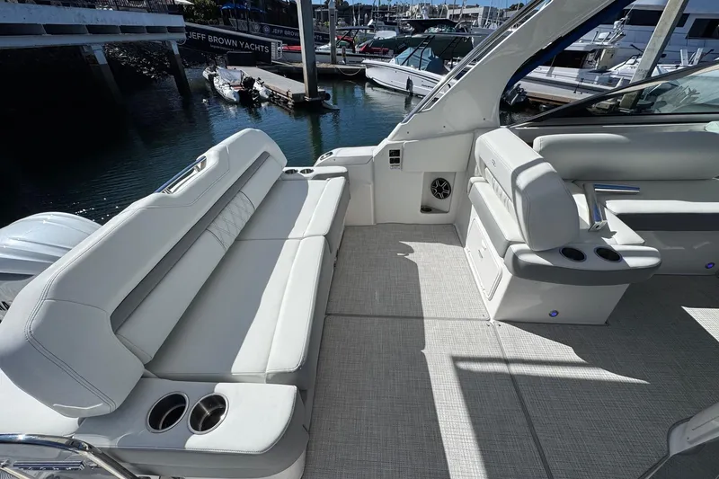 Slide: The Image of 2026 Regal 33 XO yacht interior with luxurious seating and cup holders at a marina. - 57