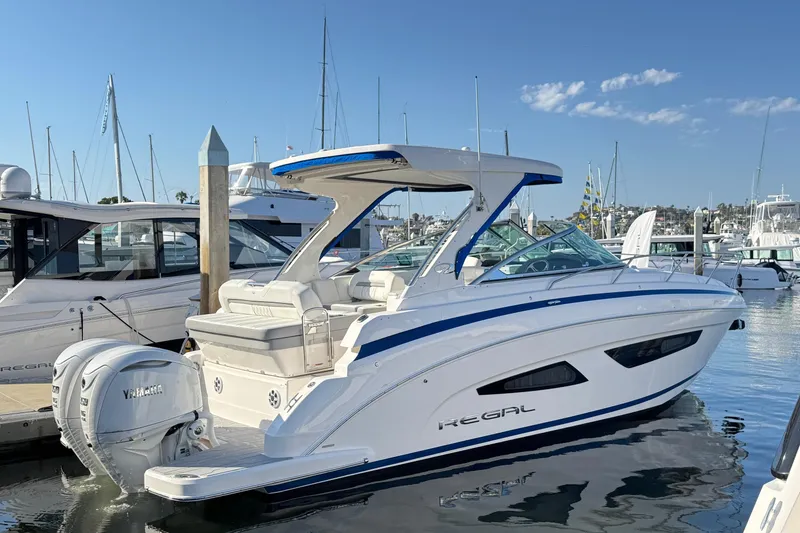 Slide: The Image of 2026 Regal 33 XO boat docked in marina, featuring sleek design and Yamaha outboard engine. - 6