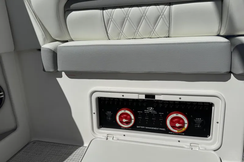 Slide: The Image of 2026 Regal 33 XO boat battery management panel with cushioned seating above. - 60