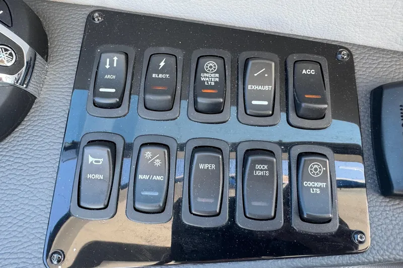 Slide: The Image of Control panel of a 2026 Regal 33 XO boat with labeled switches. - 74