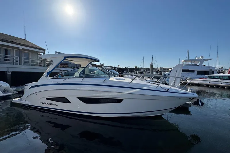 Slide: The Image of 2026 Regal 33 XO boat docked at marina under clear sky. - 9