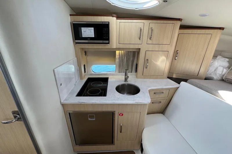Slide: The Image of 2026 Regal 33 XO yacht interior kitchen with modern appliances and wooden cabinetry. - 99