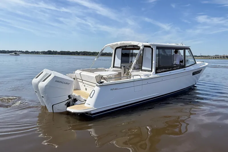 Slide: The Image of 2026 MJM 38x boat docked on calm water with clear sky background. - 6