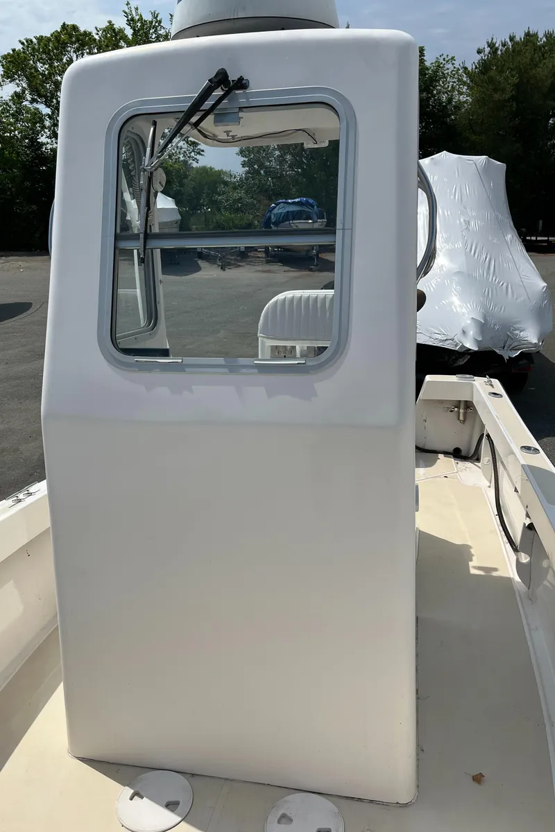 Slide: The Image of 2018 NorthCoast 190 Center Console boat with enclosed helm, parked outdoors. - 15