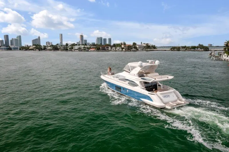 Slide: The Image of 2014 Azimut 64 Flybridge yacht cruising near city skyline on a sunny day. - 10