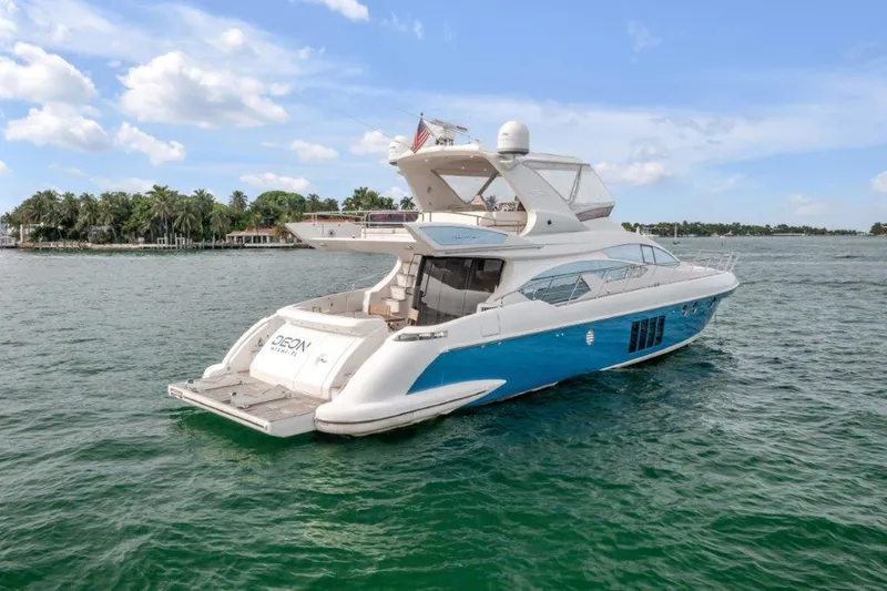 Slide: The Image of 2014 Azimut 64 Flybridge yacht cruising on a sunny day, surrounded by calm waters. - 13