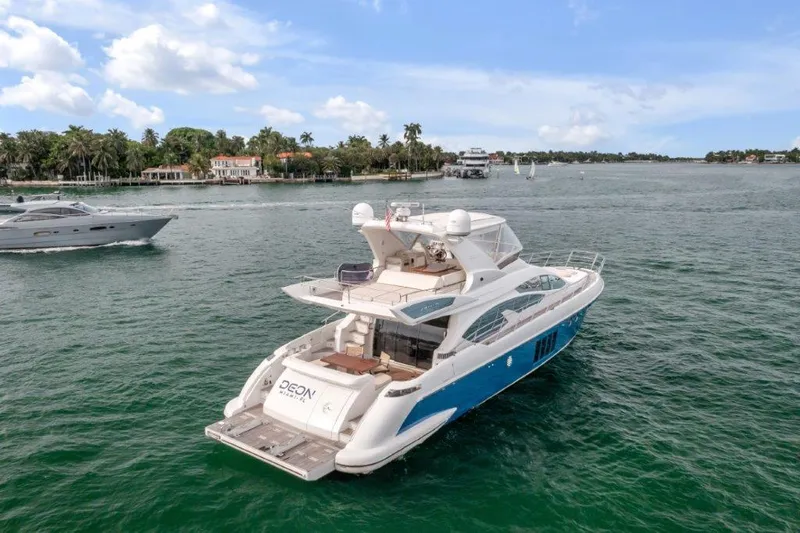Slide: The Image of 2014 Azimut 64 Flybridge yacht cruising on a scenic waterway. - 14