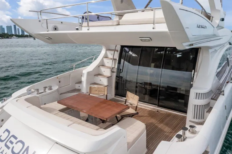 Slide: The Image of 2014 Azimut 64 Flybridge yacht with spacious deck and elegant seating area. - 16
