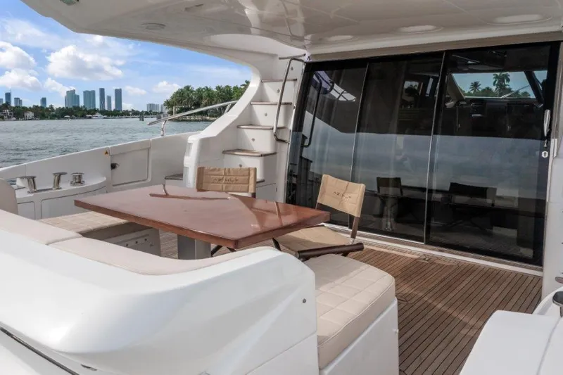 Slide: The Image of 2014 Azimut 64 Flybridge yacht deck with seating, table, and city skyline view. - 17