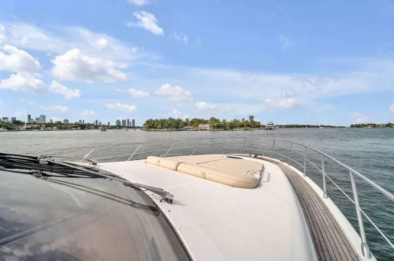 Slide: The Image of 2014 Azimut 64 Flybridge yacht cruising on a sunny day with city skyline in background. - 21
