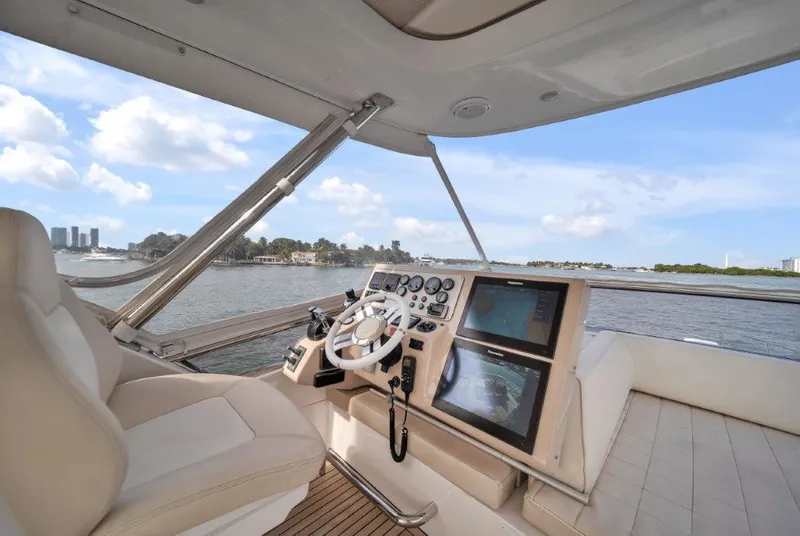 Slide: The Image of 2014 Azimut 64 Flybridge yacht helm with modern controls and scenic water view. - 26
