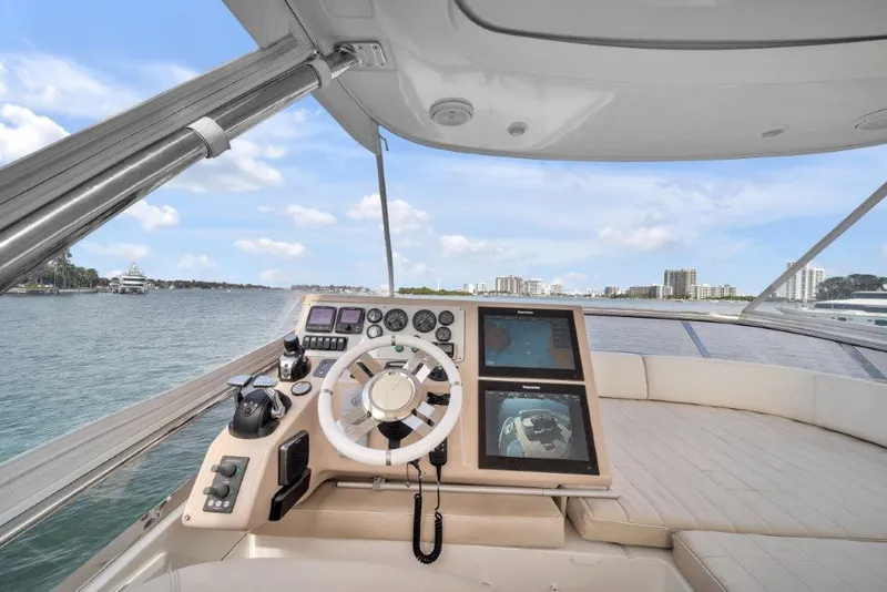 Slide: The Image of 2014 Azimut 64 Flybridge yacht helm with modern controls and city skyline view. - 27