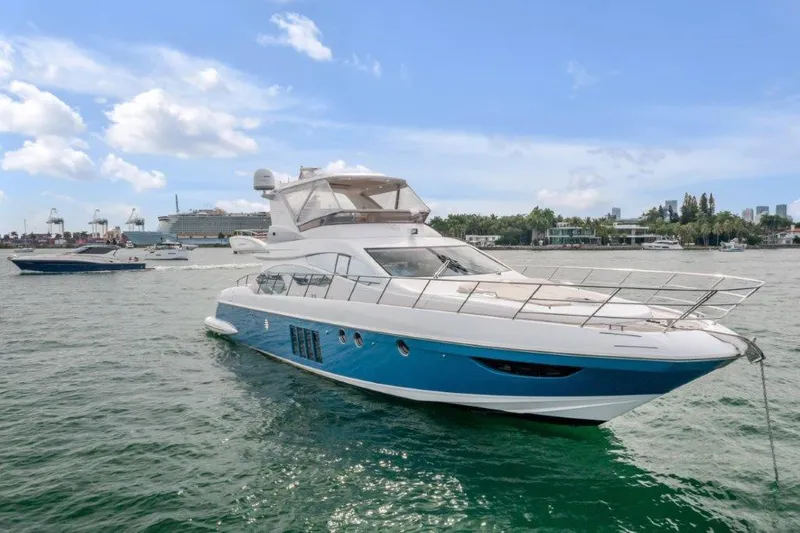 Slide: The Image of 2014 Azimut 64 Flybridge yacht on calm water under a clear blue sky. - 3