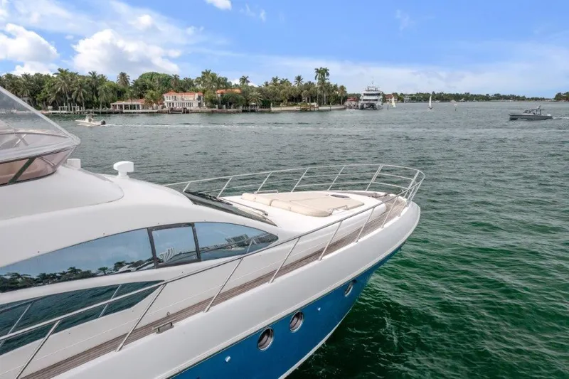Slide: The Image of Azimut 64 Flybridge 2014 yacht cruising on a scenic waterway with palm trees. - 5