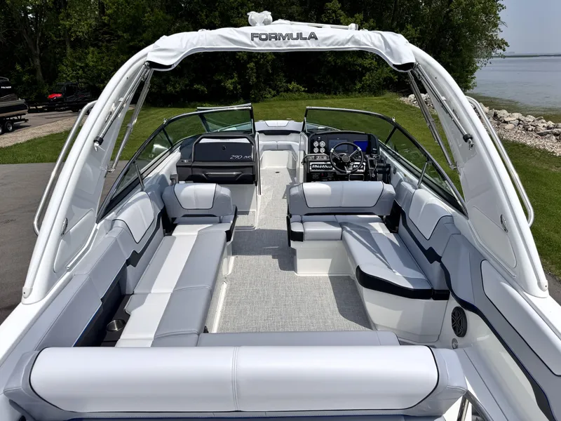 Slide: The Image of 2026 Formula 290 Bowrider boat with spacious seating and sleek design, docked near a lake. - 29