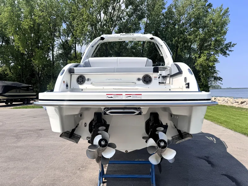 Slide: The Image of 2026 Formula 290 Bowrider boat, rear view, dual propellers, parked on a stand, outdoor setting. - 4