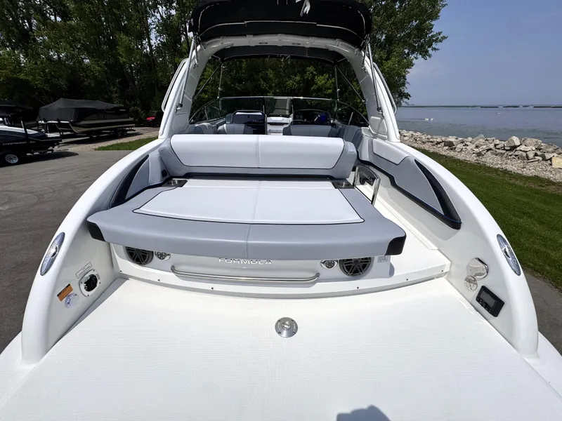 Slide: The Image of 2026 Formula 290 Bowrider boat with spacious seating, docked by a serene lakeside. - 5