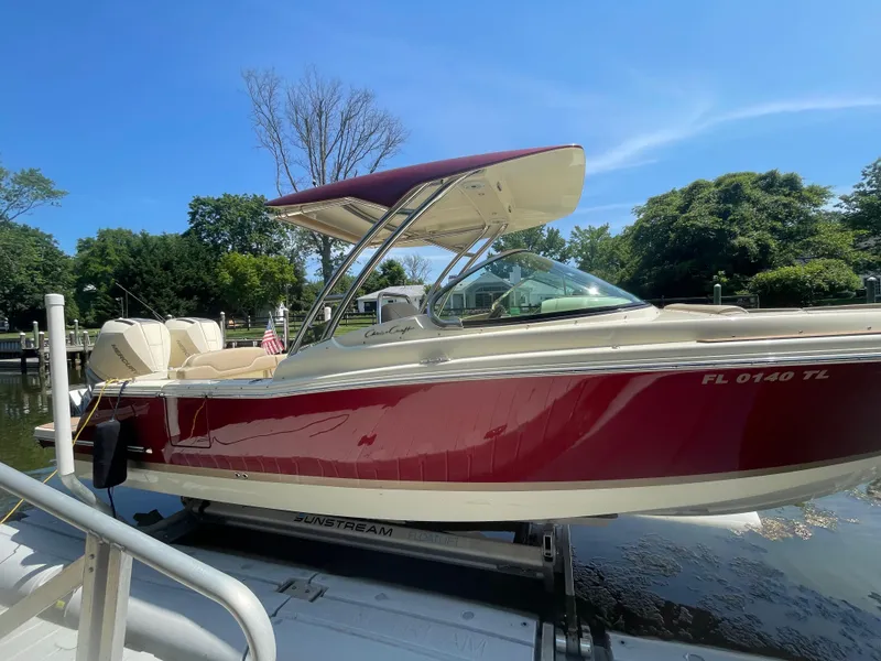 The Image of 2023 Chris-Craft Calypso 28 boat docked, featuring a sleek red and white design. - 0