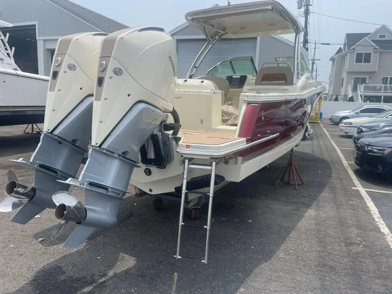 Slide: The Image of 2023 Chris-Craft Calypso 28 boat with dual outboard engines, parked outdoors. - 10