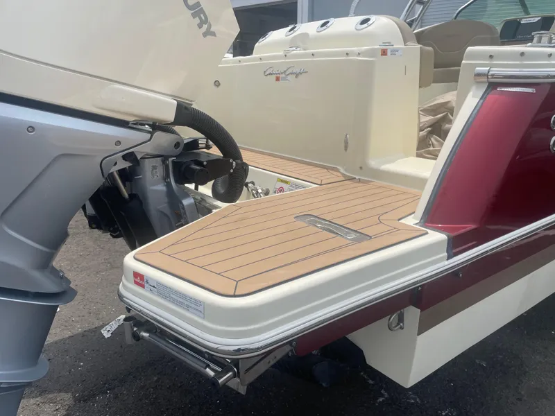 Slide: The Image of 2023 Chris-Craft Calypso 28 boat with Mercury engine, featuring a sleek wooden deck. - 14