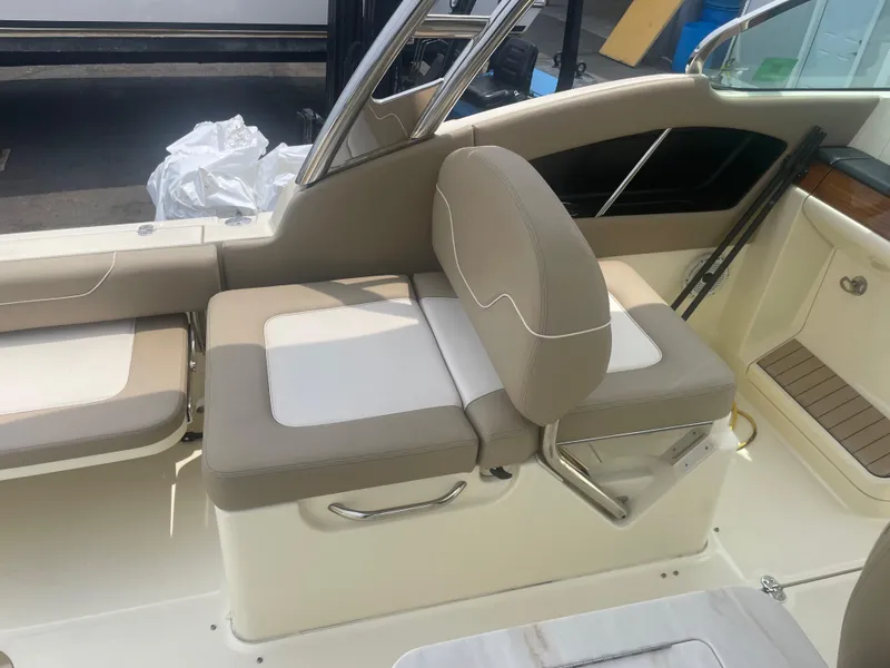 Slide: The Image of 2023 Chris-Craft Calypso 28 boat interior with beige seating and stainless steel accents. - 25