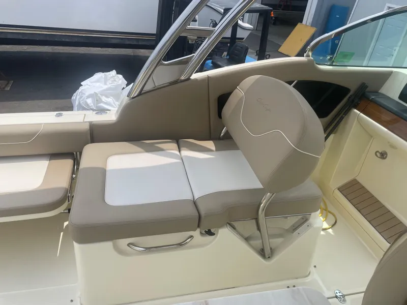 Slide: The Image of 2023 Chris-Craft Calypso 28 boat interior with beige seating and stainless steel accents. - 26