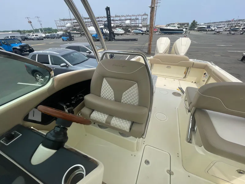 Slide: The Image of 2023 Chris-Craft Calypso 28 boat interior with beige seating and steering wheel. - 34