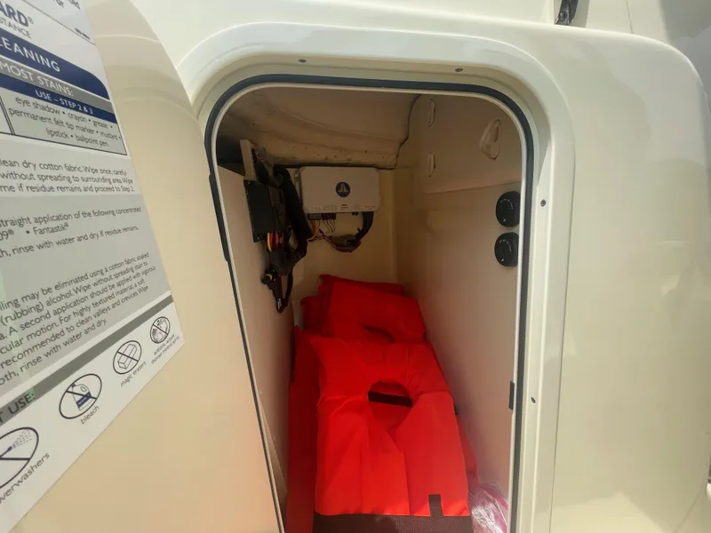 Slide: The Image of 2023 Chris-Craft Calypso 28 storage compartment with red life jackets inside. - 39