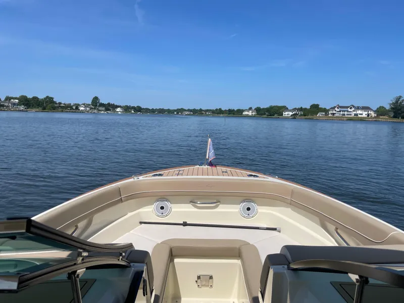 Slide: The Image of 2023 Chris-Craft Calypso 28 boat on calm water, clear sky, luxury waterfront homes. - 4