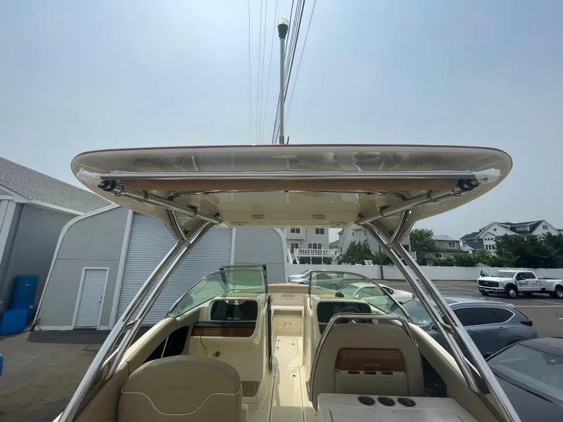 Slide: The Image of 2023 Chris-Craft Calypso 28 boat interior with seating and canopy, parked outdoors. - 40