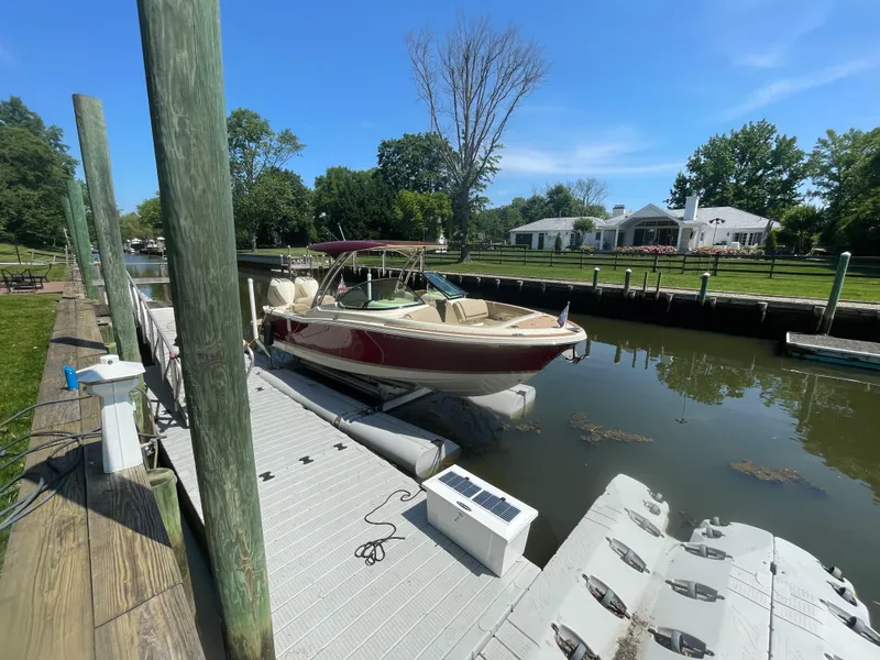 Slide: The Image of 2023 Chris-Craft Calypso 28 docked by a scenic waterfront home. - 5