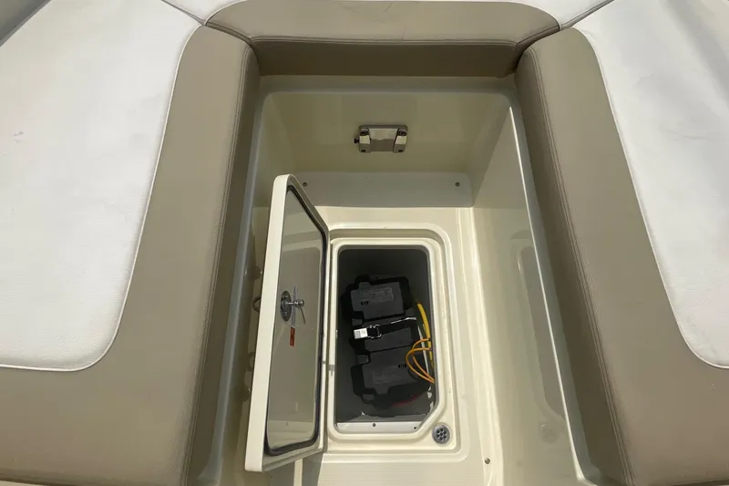 Slide: The Image of 2023 Chris-Craft Calypso 28 boat storage compartment with open hatch and visible battery. - 51
